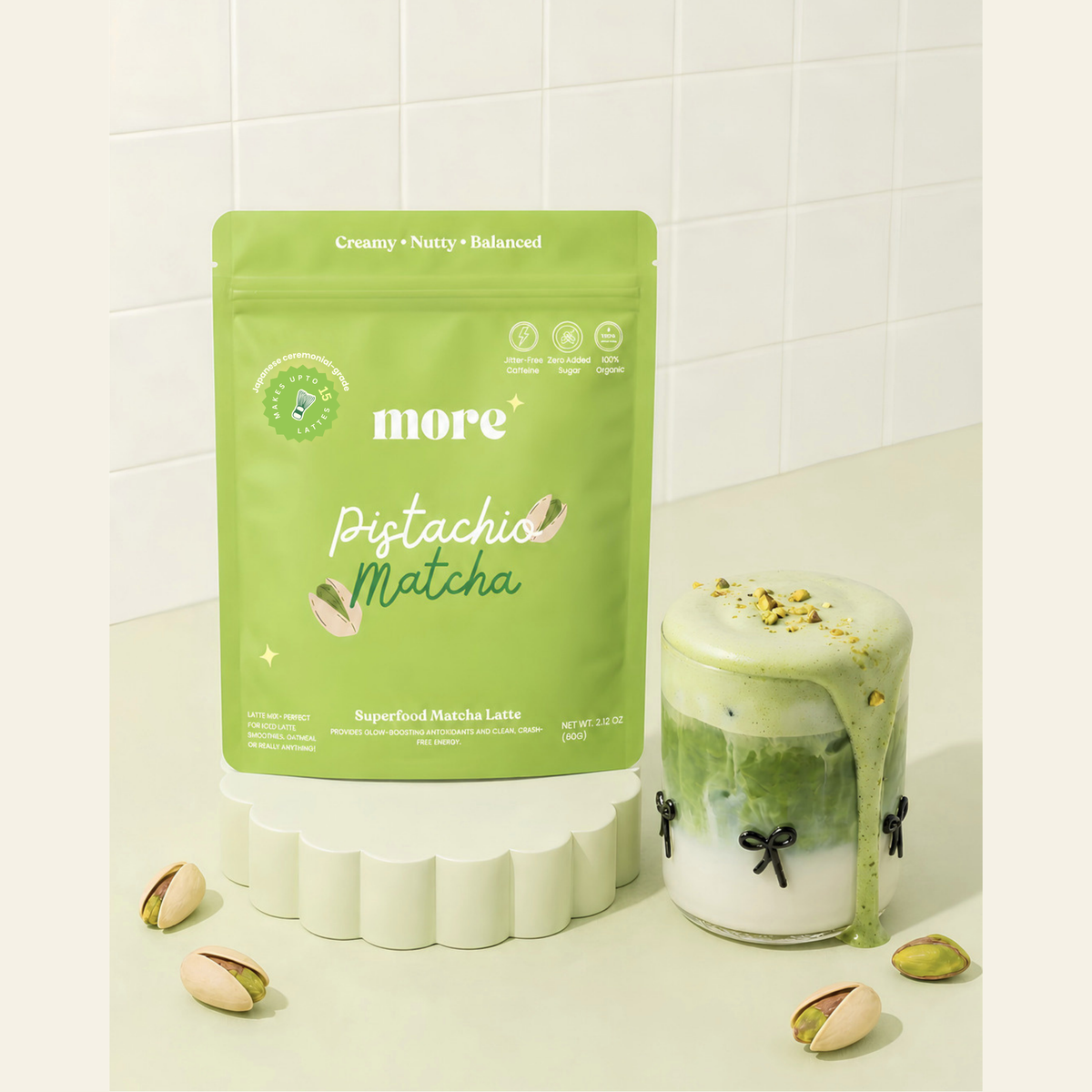 Iced pistachio matcha latte made with More Superfoods blend beside the pouch