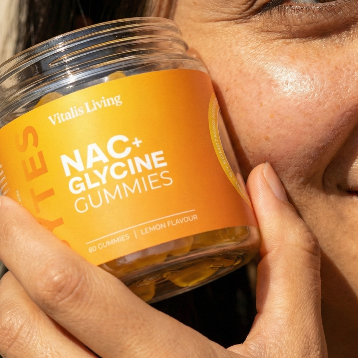 Woman holding a jar of Vitalis Living NAC plus Glycine Gummies