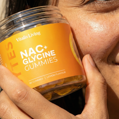 Woman holding a jar of Vitalis Living NAC plus Glycine Gummies
